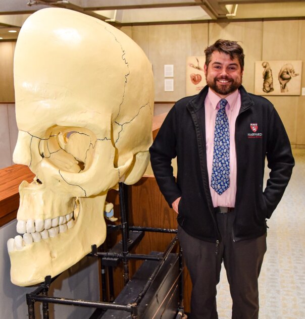 Dominic Hall standing next to large model of a human skull