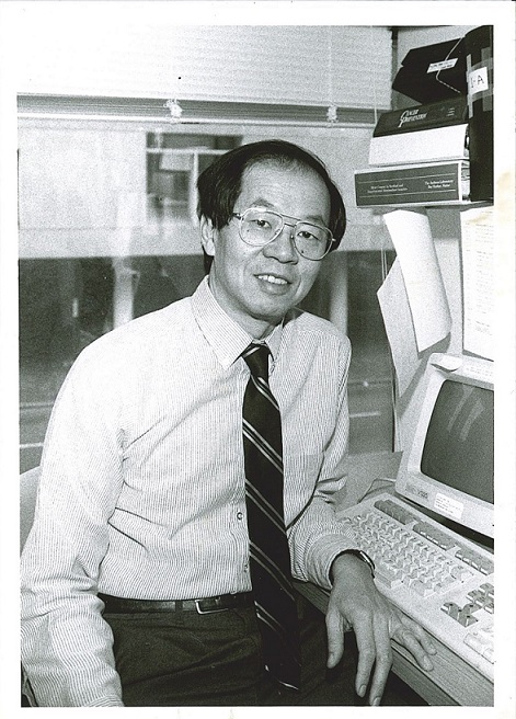 A black and white photo of Frederick P. Li at his workstation.