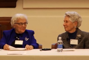 Amalie Kass and Eleanor Shore sitting at a table and speaking at an event together.