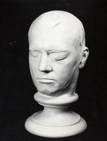 Black and white photograph of a plaster head cast of a man with his eyes closed.