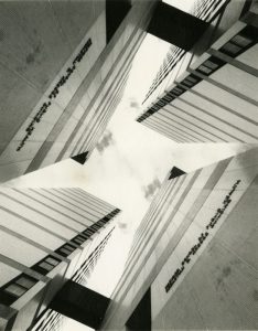 Black and white image of the Kresge Building at Harvard School of Public Health. The image is from the perspective of looking up at the sky from the ground, and the building is separated into four different columns-like structures.