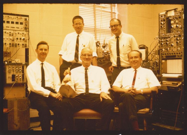 Photo of five men with electronic equipment.