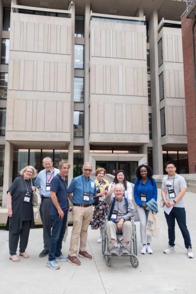 Alumni posing together in front of Countway Library.