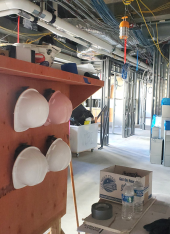 Photo of four hard hats hanging in a construction zone