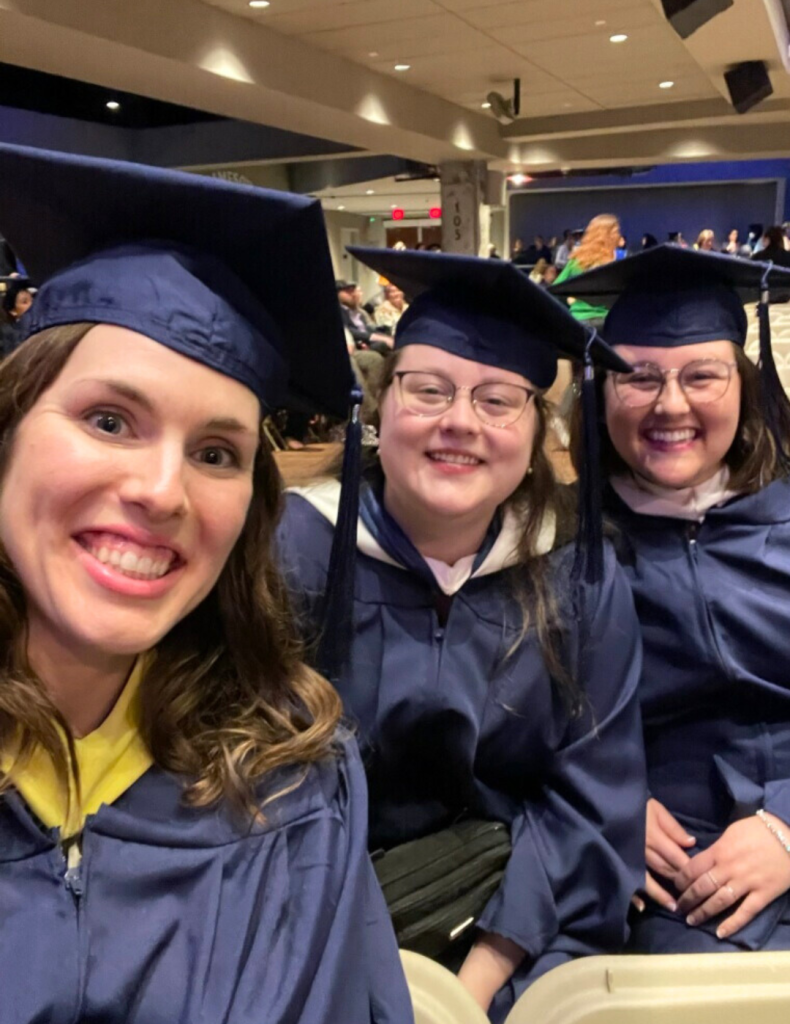 Photo of three female graduates in blue regalia