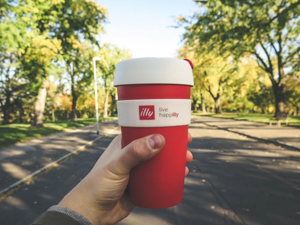 Hand holding a cup of Illy Coffee outdoors