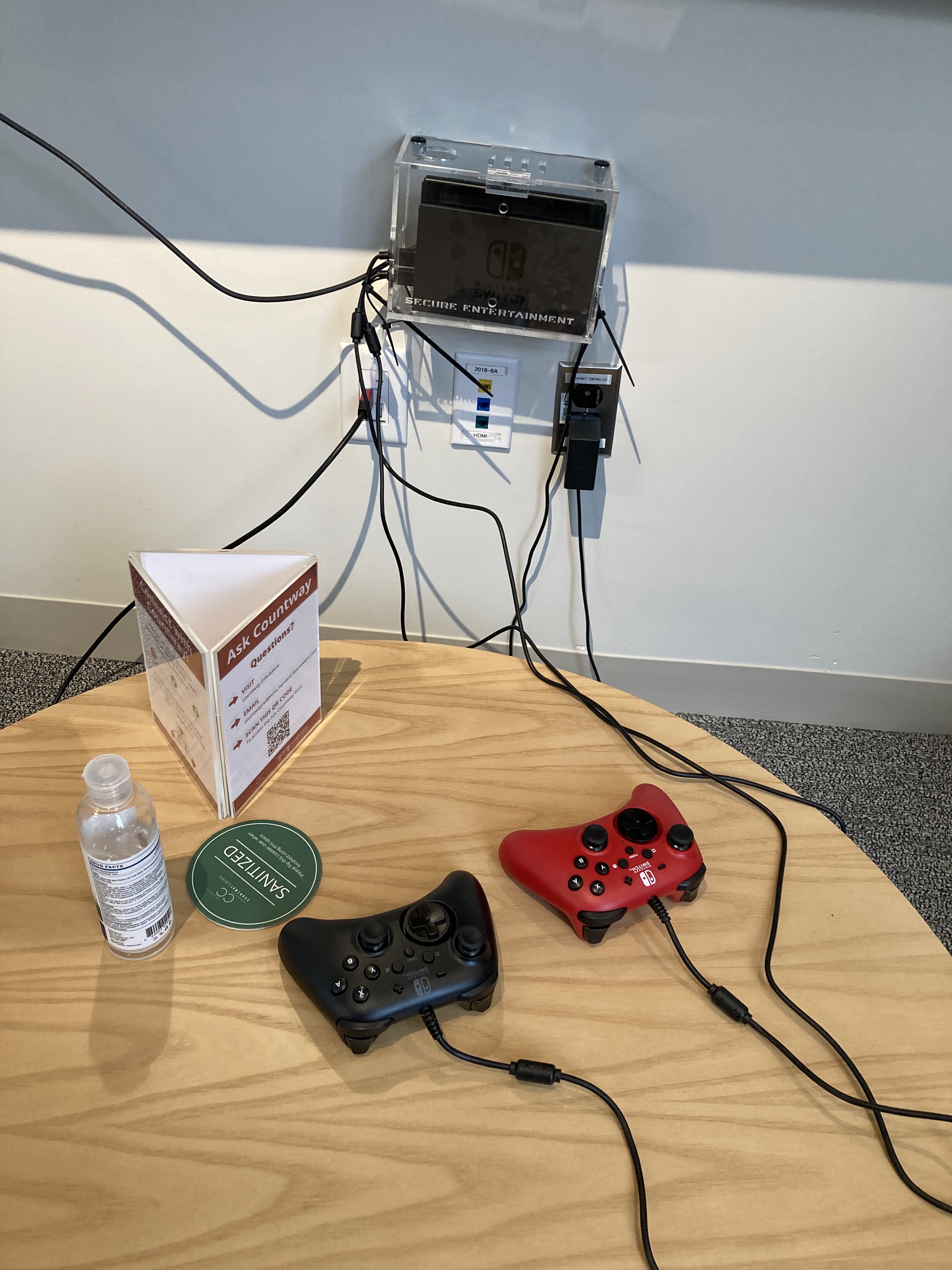 Nintendo Switch remote controls on a sanitized table next to a bottle of hand sanitizer