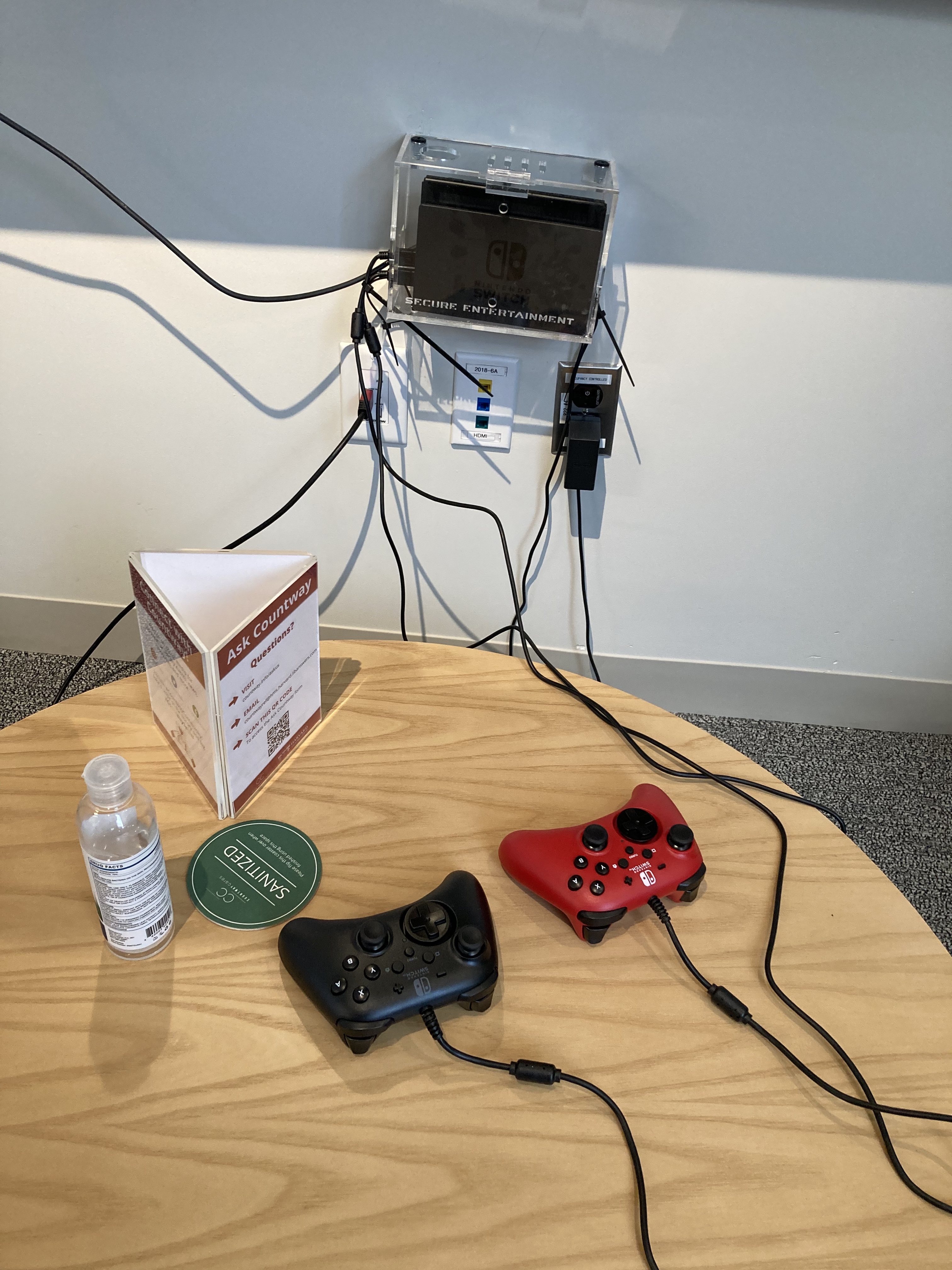 Nintendo Switch controllers on a sanitized table next to a bottle of hand sanitizer