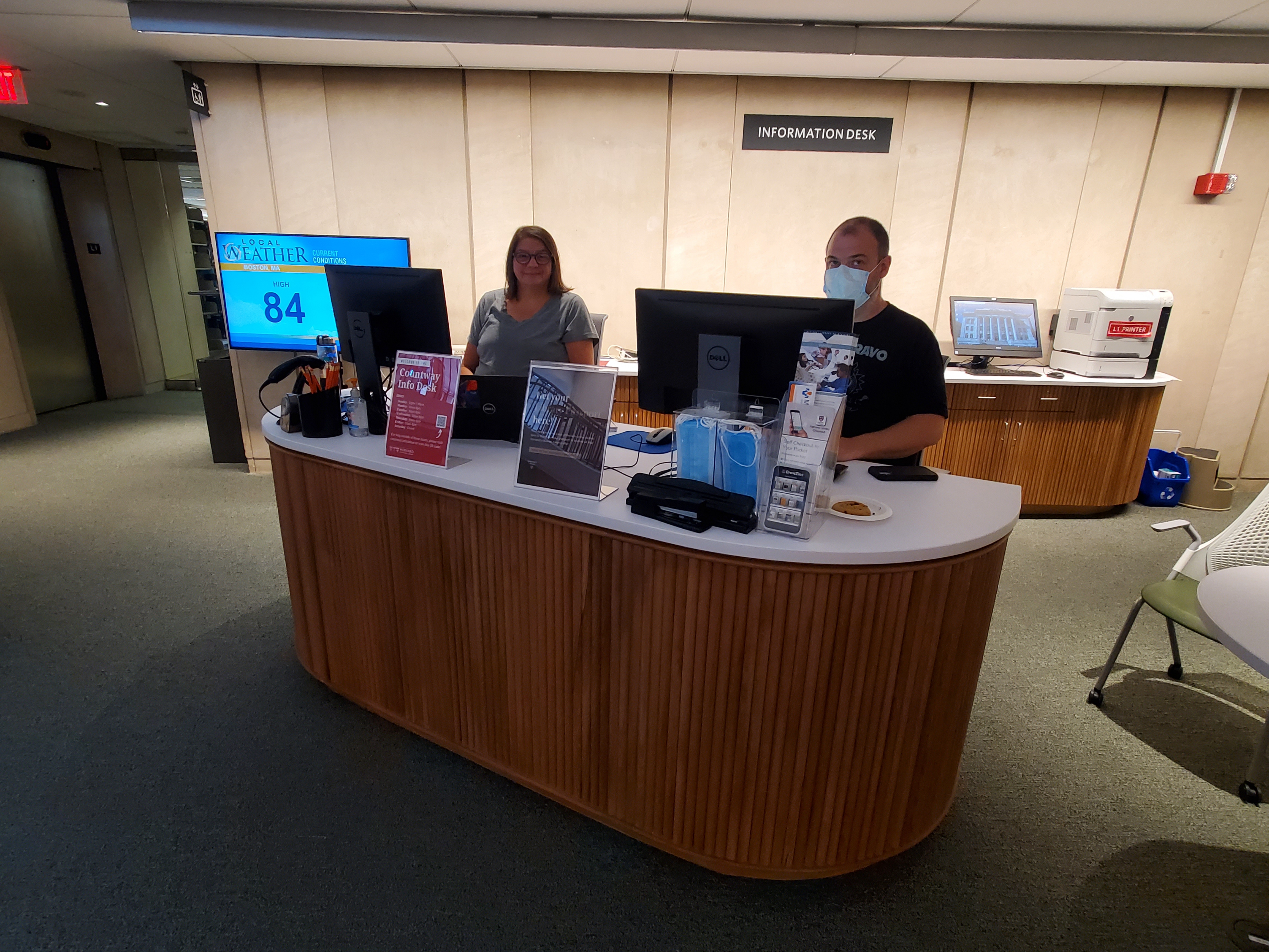 Two staff standing at the new information desk in Countway Library.