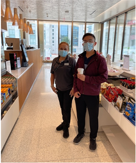 café worker and a customer holding a coffee