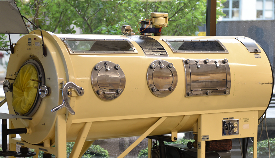 large horizontal cylindrical machine with windows on top and and several openings along the sides 