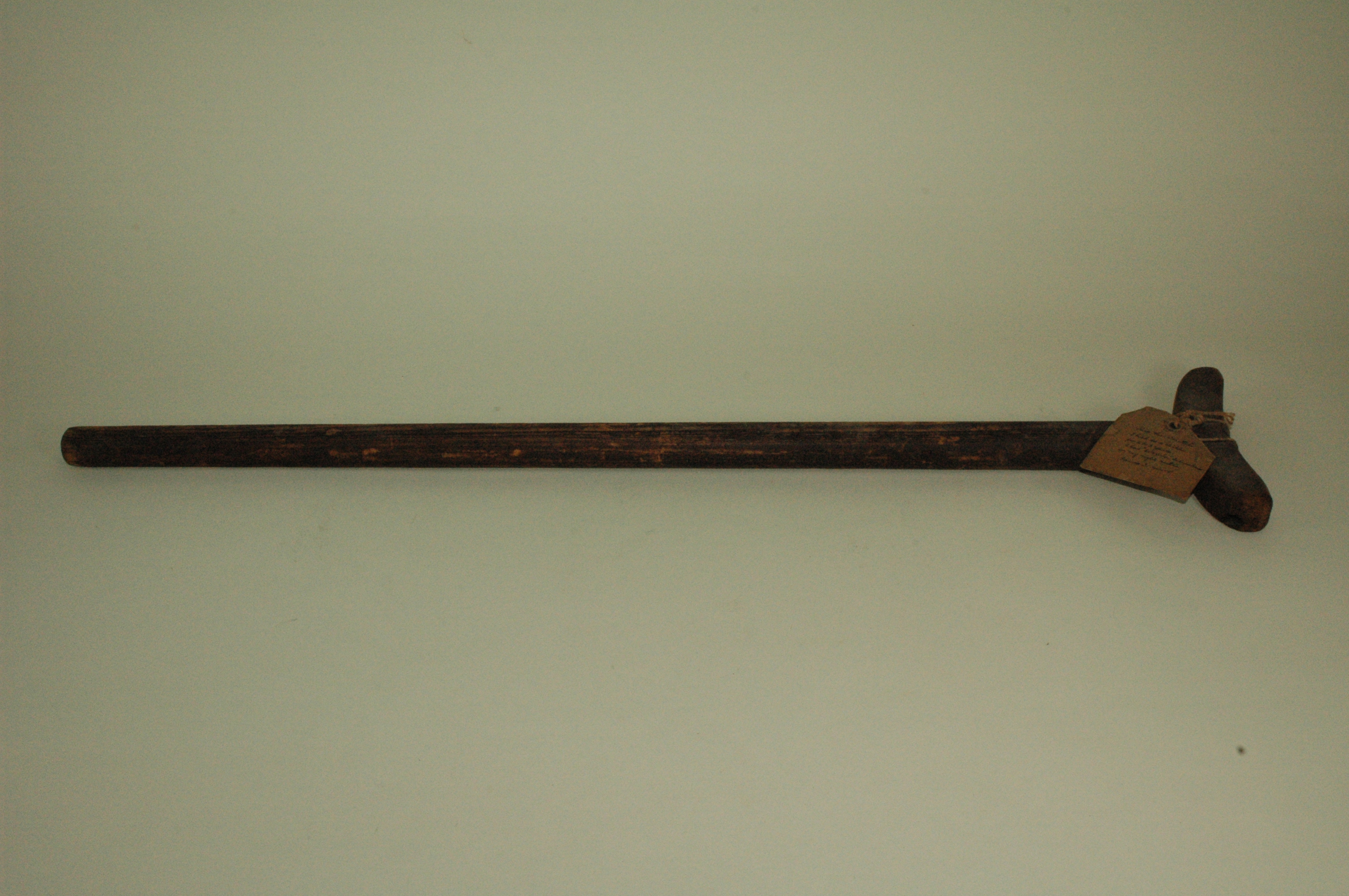 Simple wooden crutch for use by a child.  Constructed by nailing crescent-shaped underarm support piece to long wooden shaft.