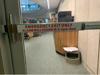 Push bar on interior glass door that says: Emergency exit only; Alarm will sound M-F 5pm-8am