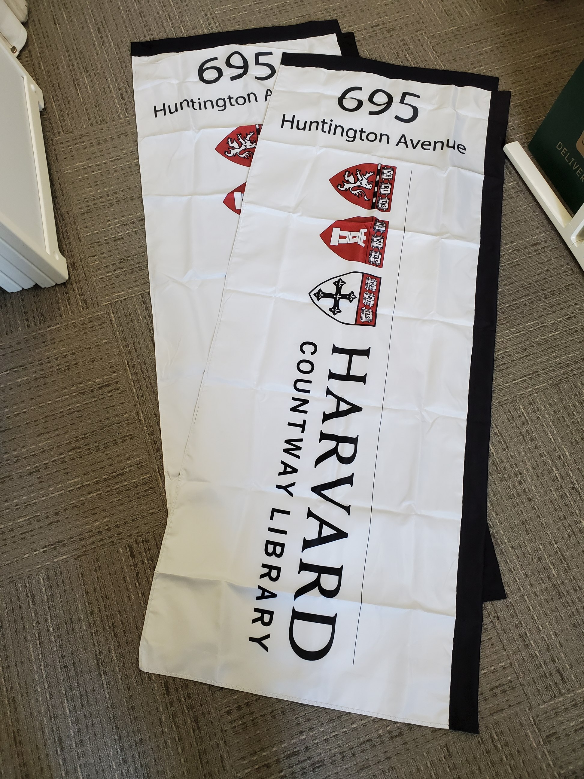 white flags with the Harvard Countway Library logo and building address (695 Huntington Avenue)