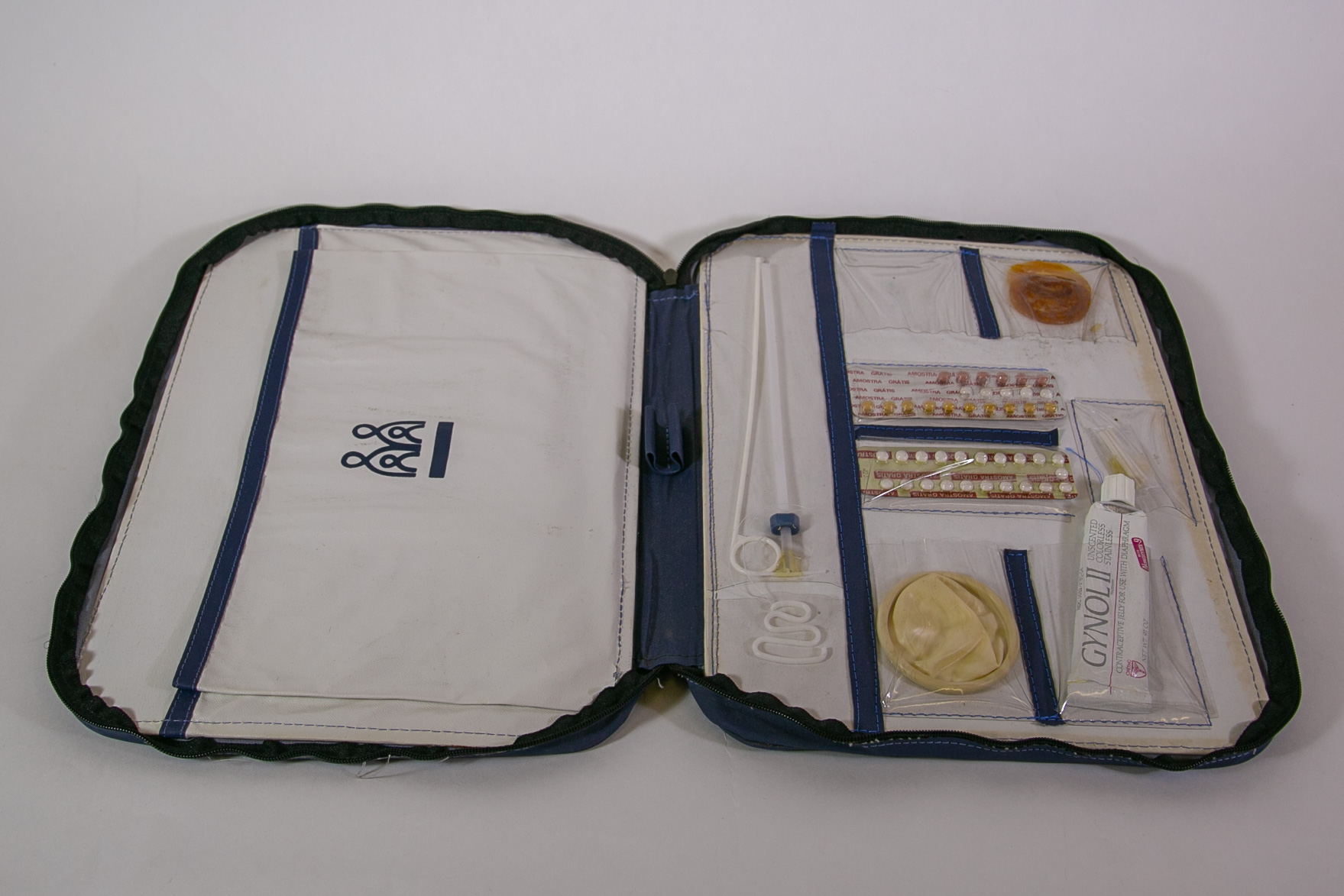 A unzippered portfolio holding multiple forms of contraceptives in plastic pockets.