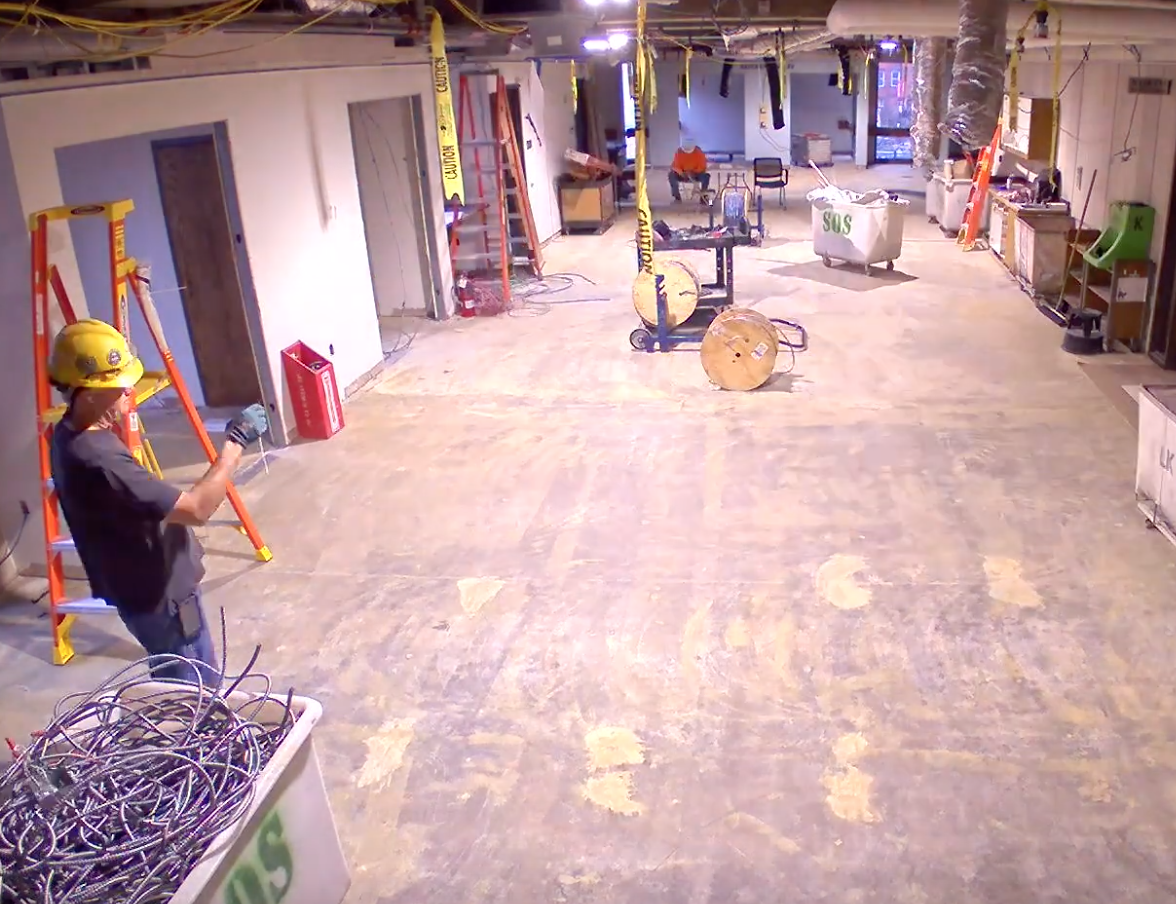 unfinished, uncarpeted space that is under construction with wires hanging from the ceiling.