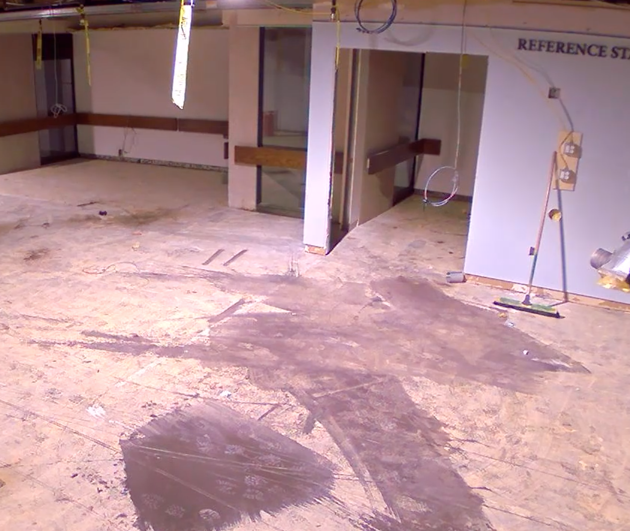 reading room with carpet and ceiling panels removed, and paint splattered on floor.