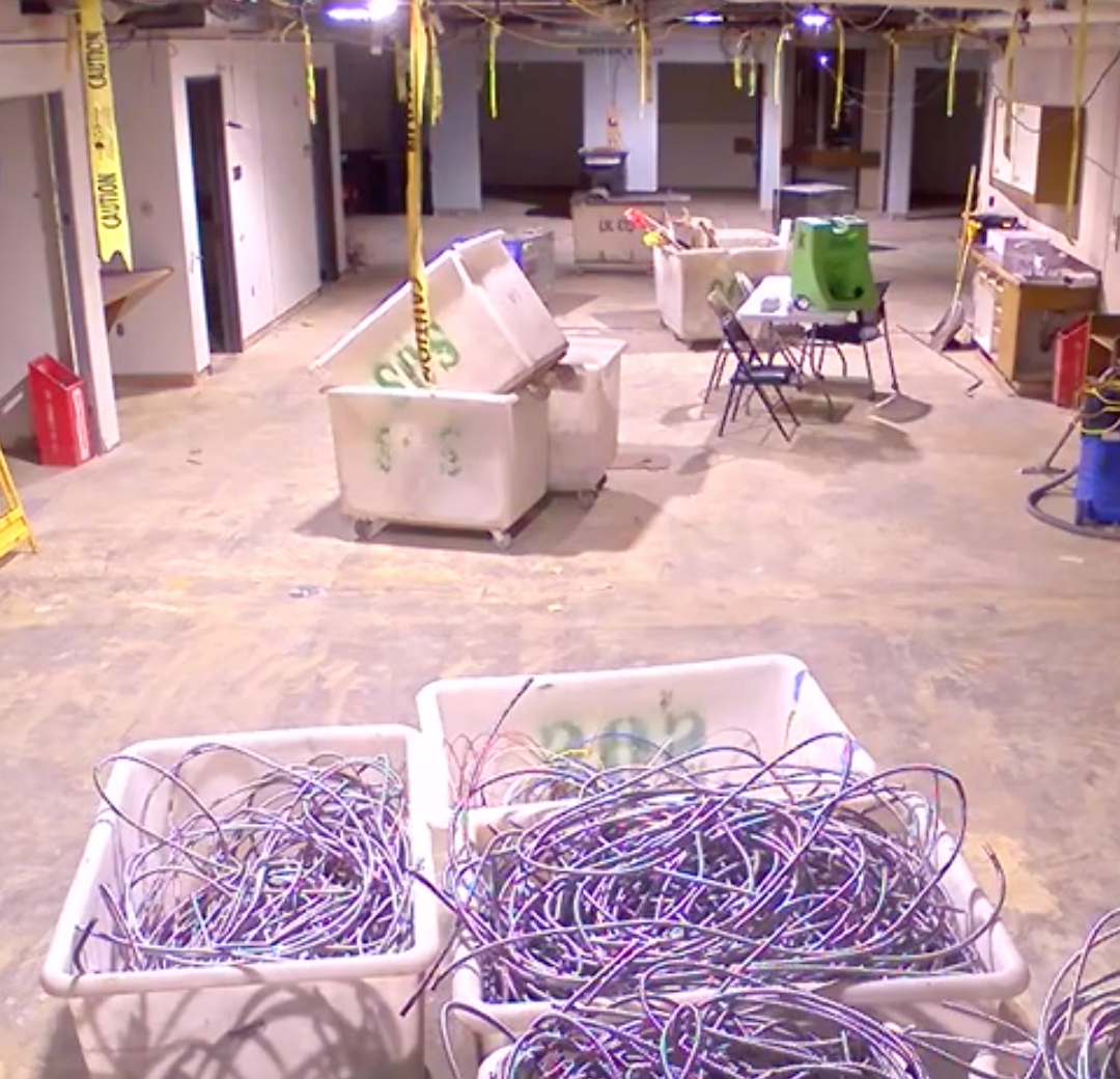 reading room with carpet and ceiling panels removed, and buckets of wire.