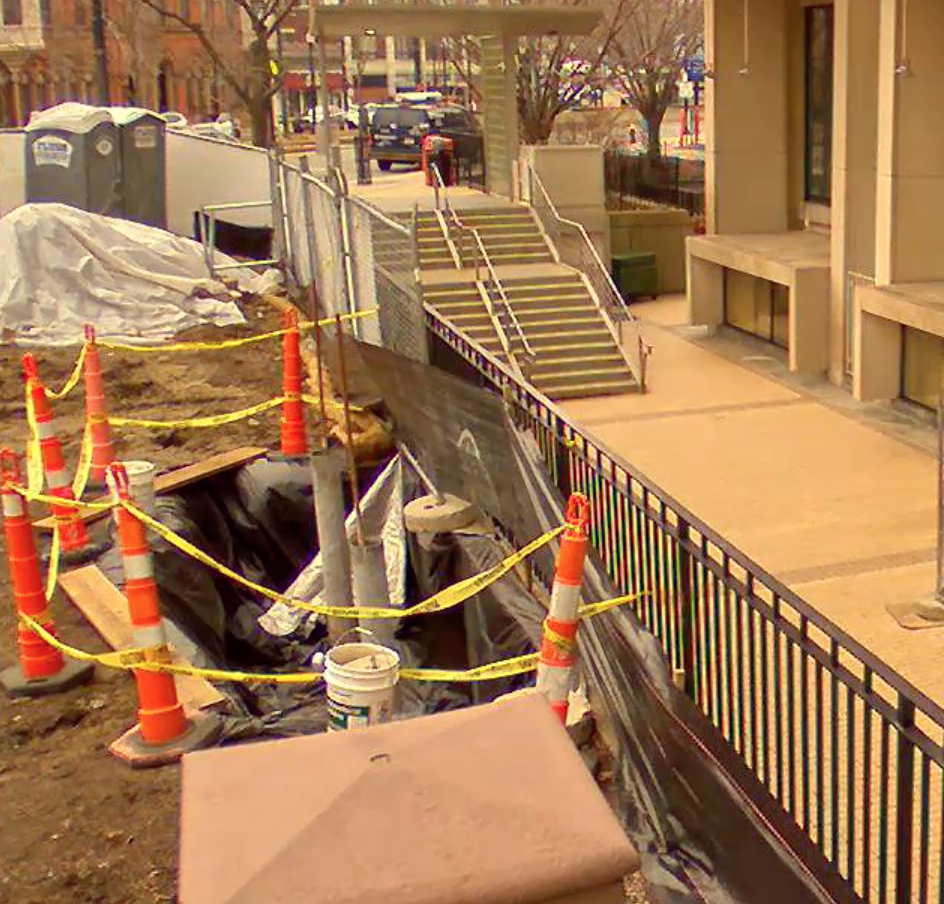 Construction cones and caution tape blocking off a small section of dirt outside.