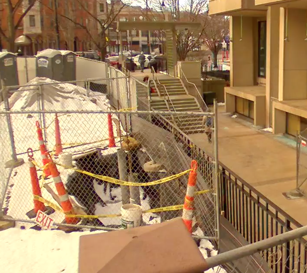 construction cones and wired fence blocking off a small area outside of the library.