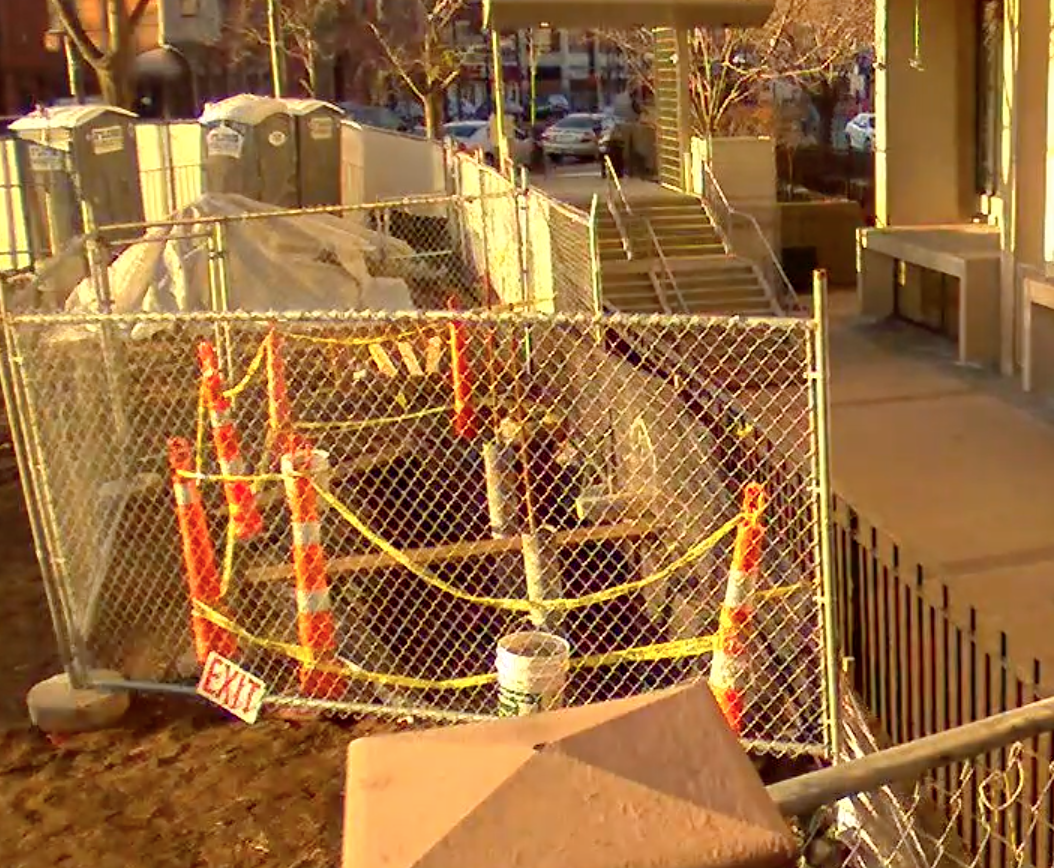 gated construction area outside of library with orange construction cones and caution tape
