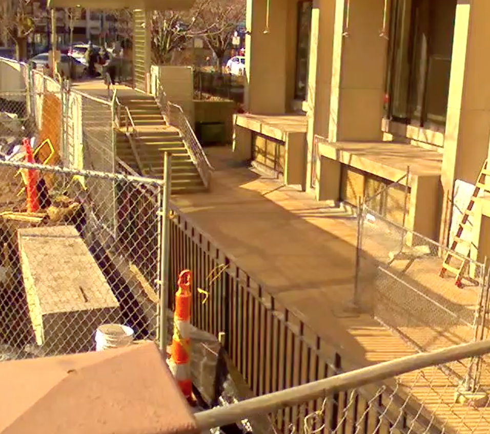 gated construction area outside of library with orange construction cones and caution tape