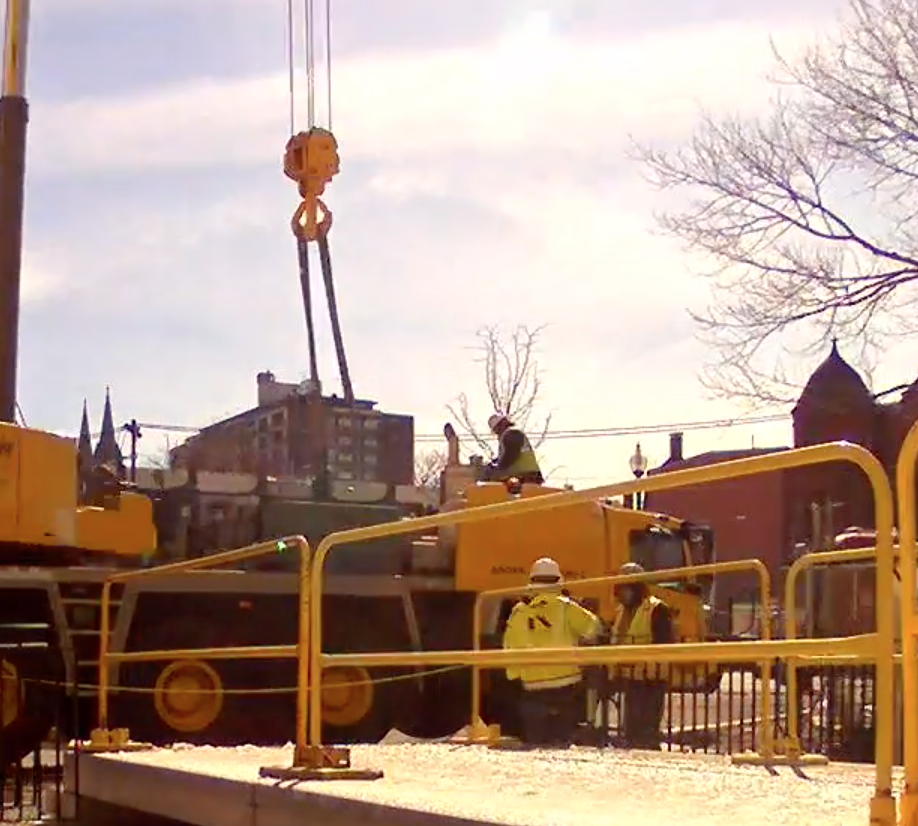 construction crane putting bridge in place for new library entrance.