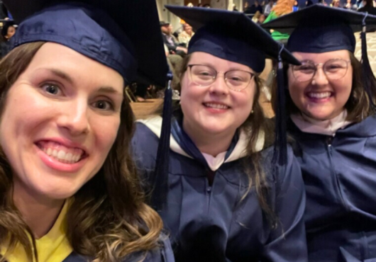 Photo of three female graduates in blue regalia
