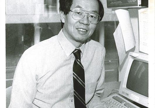 Black and white photograph of Frederick P. Li seated at his workstation.