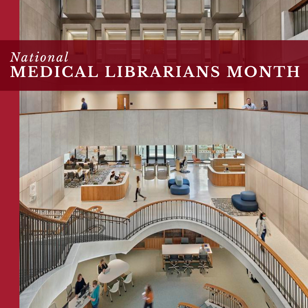 Photo of the inside of Countway library, with the words "National Medical Librarians Month" written in white on a red banner near the top.