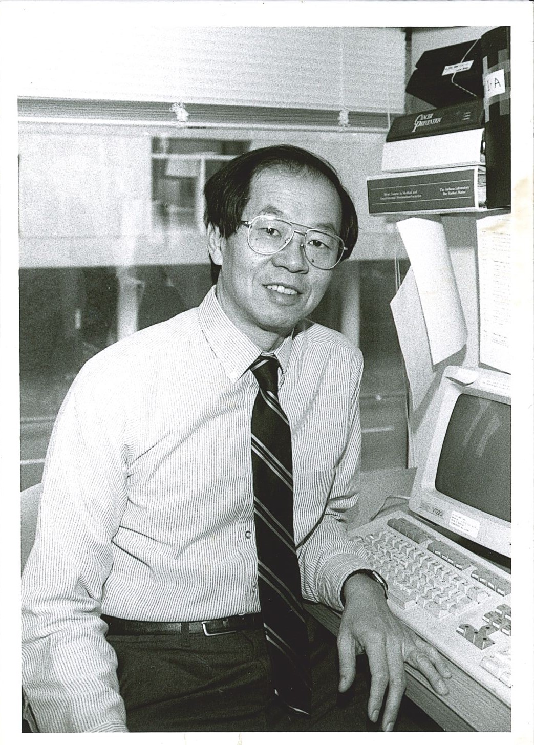 Black and white photograph of Frederick P. Li seated at his workstation.