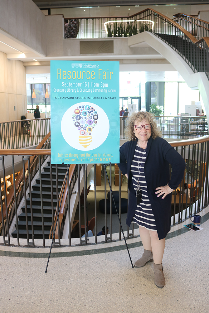 library director in front of resource fair poster
